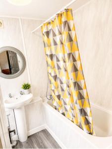 a bathroom with a shower curtain and a sink at Cozy Corner in Wolverhampton City Centre in Wolverhampton