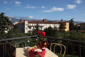 a table with a vase of flowers on a balcony at Hotel PRime in Pistoia