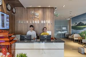 two people sitting at a counter in a hotel lobby at Thanh Long Hotel - Bach Dang in Ho Chi Minh City