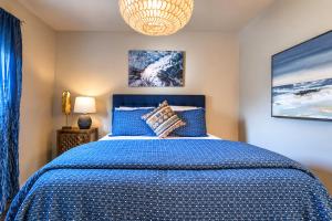 a bedroom with a blue bed and a chandelier at Elevate Your Stay Chic 1-Bed Condo Courtyard in Dallas