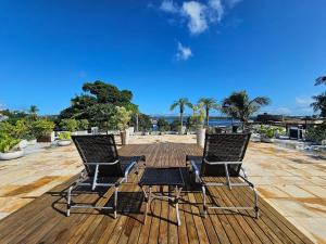 three chairs sitting on top of a wooden deck at Residencial Mirante in Itacaré