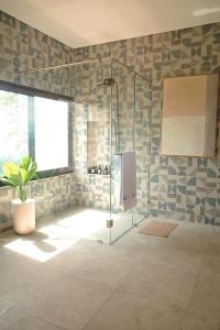 a bathroom with a shower with a glass door at The Casa Lunamoon in Kintamani +48 photos
