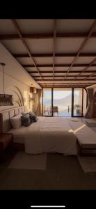 a large white bed in a room with a view at The Casa Lunamoon in Kintamani