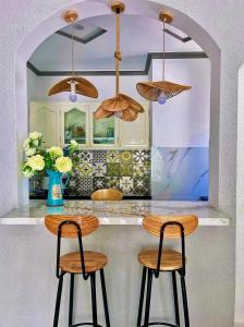 a kitchen with two stools at a counter with umbrellas at Hoàng Nga 1 Apartment in Phan Thiet