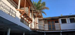 a building with a balcony and a palm tree at Managua Inn in Managua