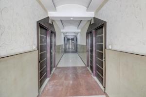 a corridor of a building with doors and a long hallway at Hotel O Mukut Mahal in Meerut