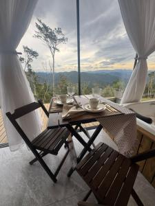 a table and chairs on a balcony with a view at Chalé Refugio nas montanhas in Guaratuba
