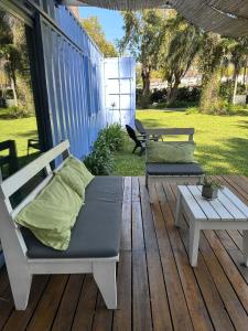 a porch with two benches and a bed and a table at Diva gues del Pereyra Sur in Villa Elisa