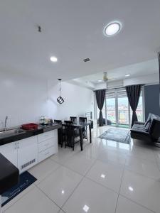 a kitchen and living room with a table and chairs at Ezae Studio D'Perdana Apartment in Kota Bharu