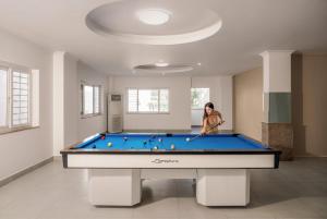 a woman is playing pool on a pool table at KLY Hotel & Retreat in Vung Tau