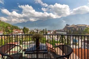 a table and chairs on a balcony with a view at Sapa Panorama Hotel in Sapa