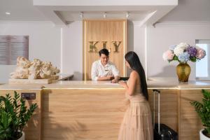a woman in a dress standing at a counter with a man at KLY Hotel & Retreat in Vung Tau +36 photos