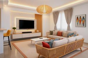 a living room with a couch and a tv at Luxury Comfort Villa in Punta Cana