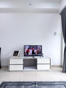 a living room with a tv on a white wall at Ezae Studio D'Perdana Apartment in Kota Bharu