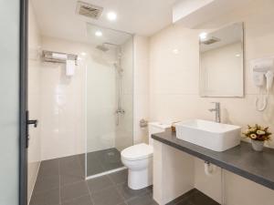 a white bathroom with a sink and a toilet at Cloud House Sapa in Sapa