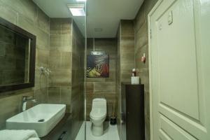 a bathroom with a white toilet and a sink at Central 2 bed Apt near Devon House in Kingston