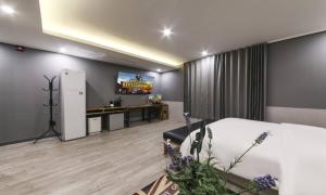 a bedroom with a bed and a tv on a wall at Daegu Seongseo Hotel Series 5.0 in Daegu
