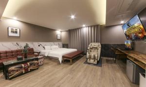 a bedroom with a bed and a couch and a television at Daegu Seongseo Hotel Series 5.0 in Daegu