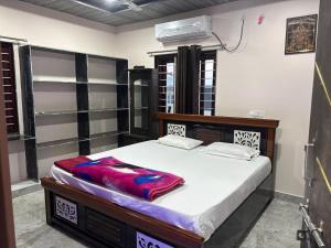 a bedroom with a large bed with white sheets at Vasavi Homes in Mādhavaram