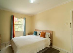 a bedroom with a white bed and a window at Central 2 bed Apt near Devon House in Kingston