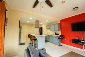 a kitchen with a red accent wall and a couch at Central 2 bed Apt near Devon House in Kingston