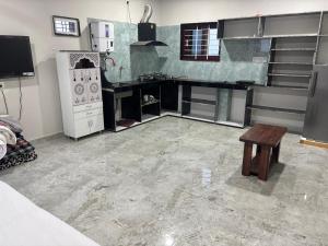a room with a kitchen with a stove and a table at Vasavi Homes in Mādhavaram