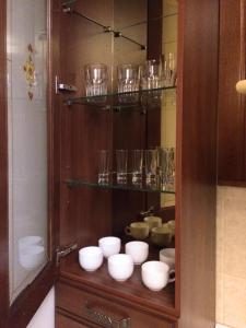 d'une armoire en bois avec des bols et des verres dans l'établissement Alexandra Apartments Industrial Bridge, à Kiev