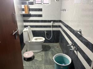 a bathroom with a toilet and a bucket in it at Vasavi Homes in Mādhavaram