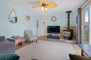 a living room with a fireplace and a stove at "At the Eau" - Charming 2 Bedroom Cottage! in Erieau