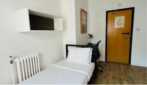 a bedroom with a bed and a wooden door at YMCA Hotel in London