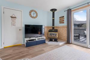 a living room with a fireplace and a flat screen tv at "At the Eau" - Charming 2 Bedroom Cottage! in Erieau