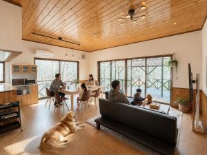 a family in a living room with a dog laying on the floor at BBQ屋根付き大型ウッドデッキ川のせせらぎを聴きながら贅沢時間ペット同伴OK森と音に癒されるコテージ Rill in Nasu +51 photos