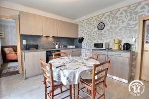 a dining room with a table and chairs in a kitchen at Les papillons in Plérin