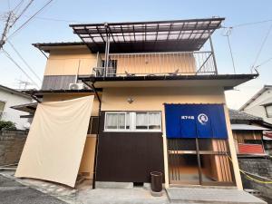 a house with a blue door and a building at 城下の宿庵 in Ōzu