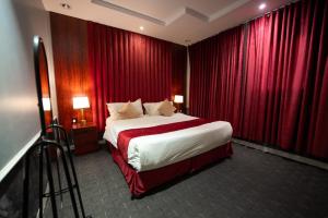 a bedroom with a large bed with red curtains at الجوهرة بارك للشقق المخدومة 6 in Riyadh +47 photos