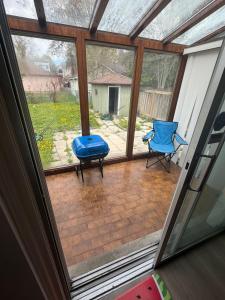 a screened in porch with a blue ottoman and a chair at Luxury Fun Villa in Toronto