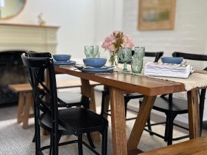 a wooden table with plates and glasses on it at Tamara Cottage Historic Warmth in Hobart