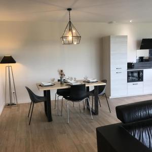 a dining room table and chairs in a living room at Le balcon des gorges in Saint-Rome-de-Dolan