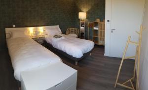 a hotel room with two beds and a chair at Le balcon des gorges in Saint-Rome-de-Dolan