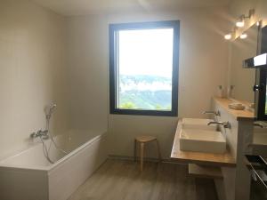 a bathroom with a tub and a sink and a window at Le balcon des gorges in Saint-Rome-de-Dolan +19 photos