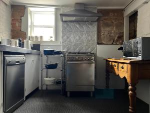 a kitchen with a stainless steel stove and a sink at Tamara Cottage Historic Warmth in Hobart