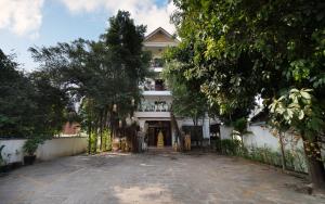 a large white building with trees in front of it at Harmony Hotel in Siem Reap +31 photos
