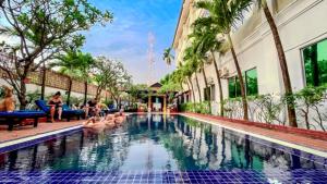a pool at a hotel with flamingos in the water at Harmony Hotel in Siem Reap