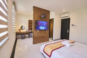 a bedroom with a bed and a flat screen tv at La Mejor Homestay in Quang Tri