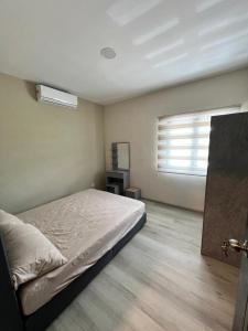 a bedroom with a bed and a window in it at JEC Suites in Kuching +4 photos