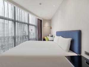 a hotel room with a large bed and a window at CHECK inn Taipei Xinyi in Taipei