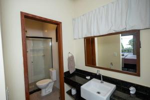 a bathroom with a sink and a toilet and a mirror at Suíte dos Reis in Angra dos Reis +76 photos