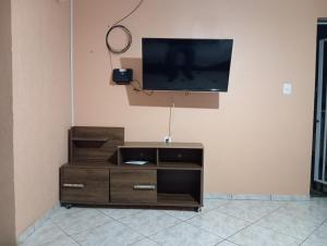a entertainment center with a flat screen tv on a wall at Ampla acomodação e com ótimo localização in Machadinho
