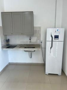 a kitchen with a white refrigerator and a sink at Apartamento 2 Quartos centro da cidade in Parauapebas