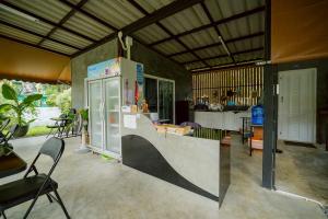 a kitchen with a counter and a refrigerator at Baanklongkok in Ban Map Khangkhao +16 photos